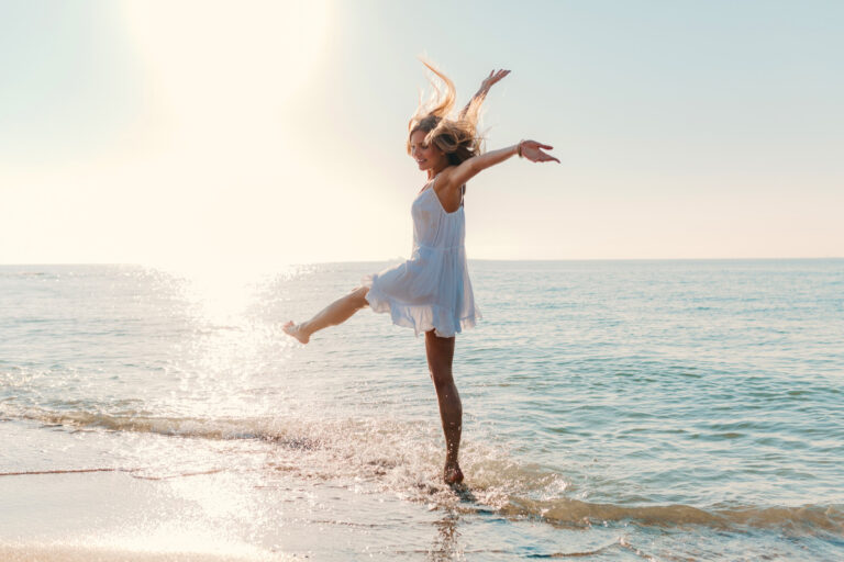 young-attractive-happy-woman-dancing-turning-around-by-sea-beach-sunny-summer-fashion-style (1)